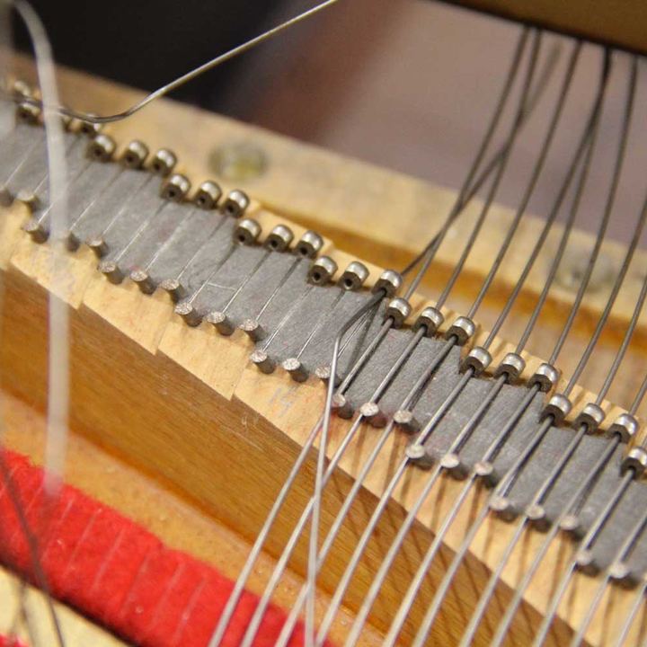 Chevilles d'accord et cordes d'un piano droit, plan serré